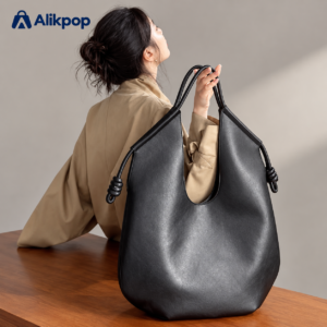 Adult model carrying a black PU tote bag with knotted straps, with an Alikpop logo in the image corner